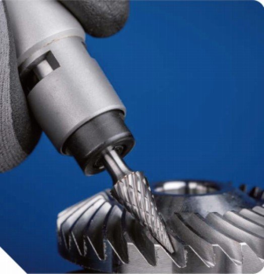Tungsten carbide rotary burrs cutting through metal